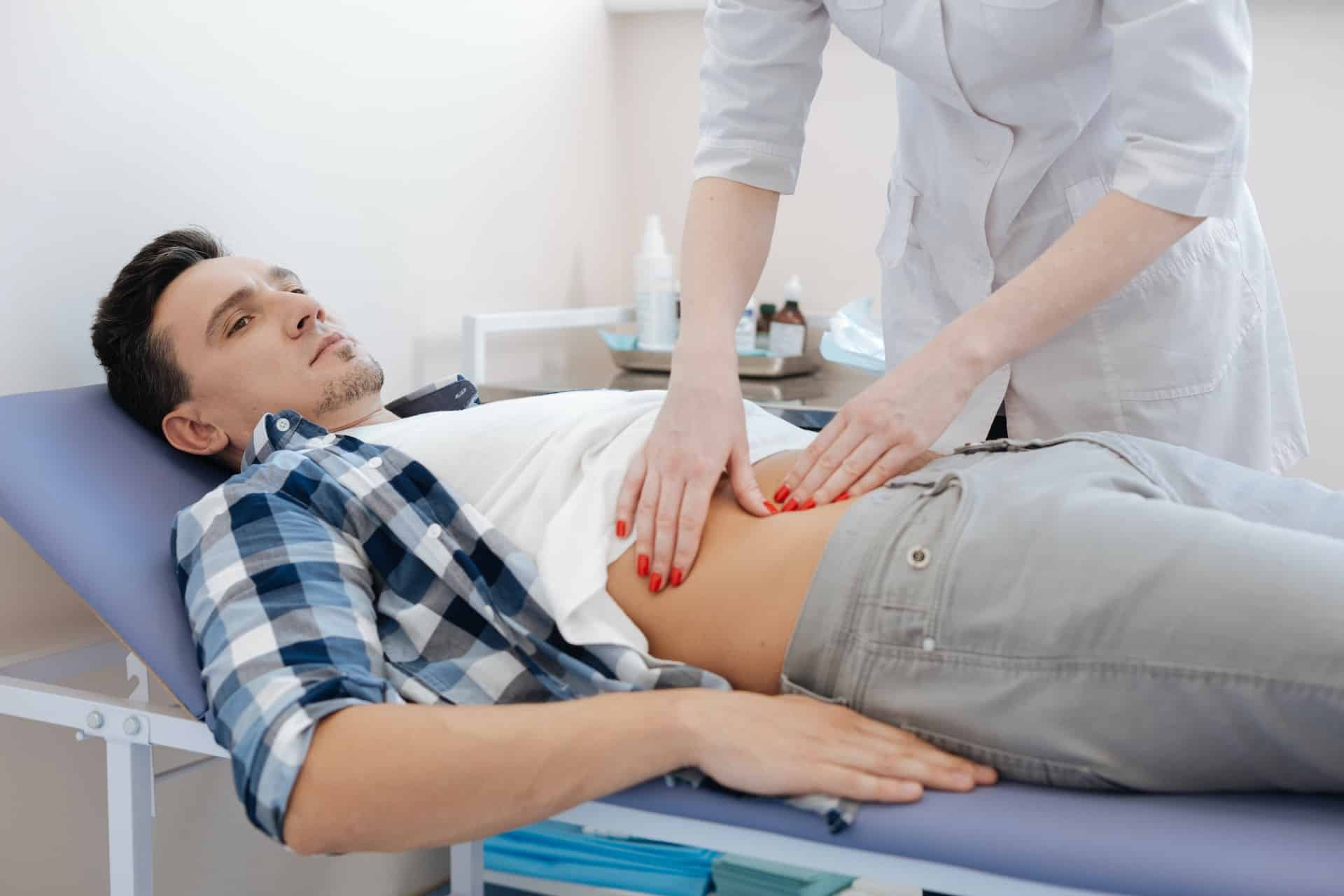 man with stomach pain getting a checkup